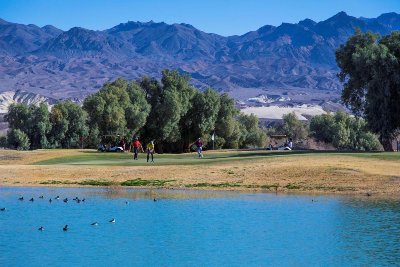 The Inn At Death Valley Exterior photo Golfers at the 18th green of the Mountain Shadows Golf Club